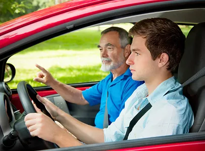 Un instructeur de conduite âgé montre la route à un jeune conducteur à Toulouse en Haute-Garonne 31