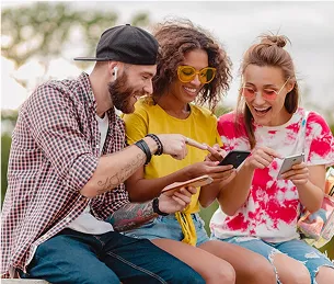 Trois jeunes amis joyeux interagissent avec des smartphones, partageant un moment amusant à Toulouse en Haute-Garonne 31